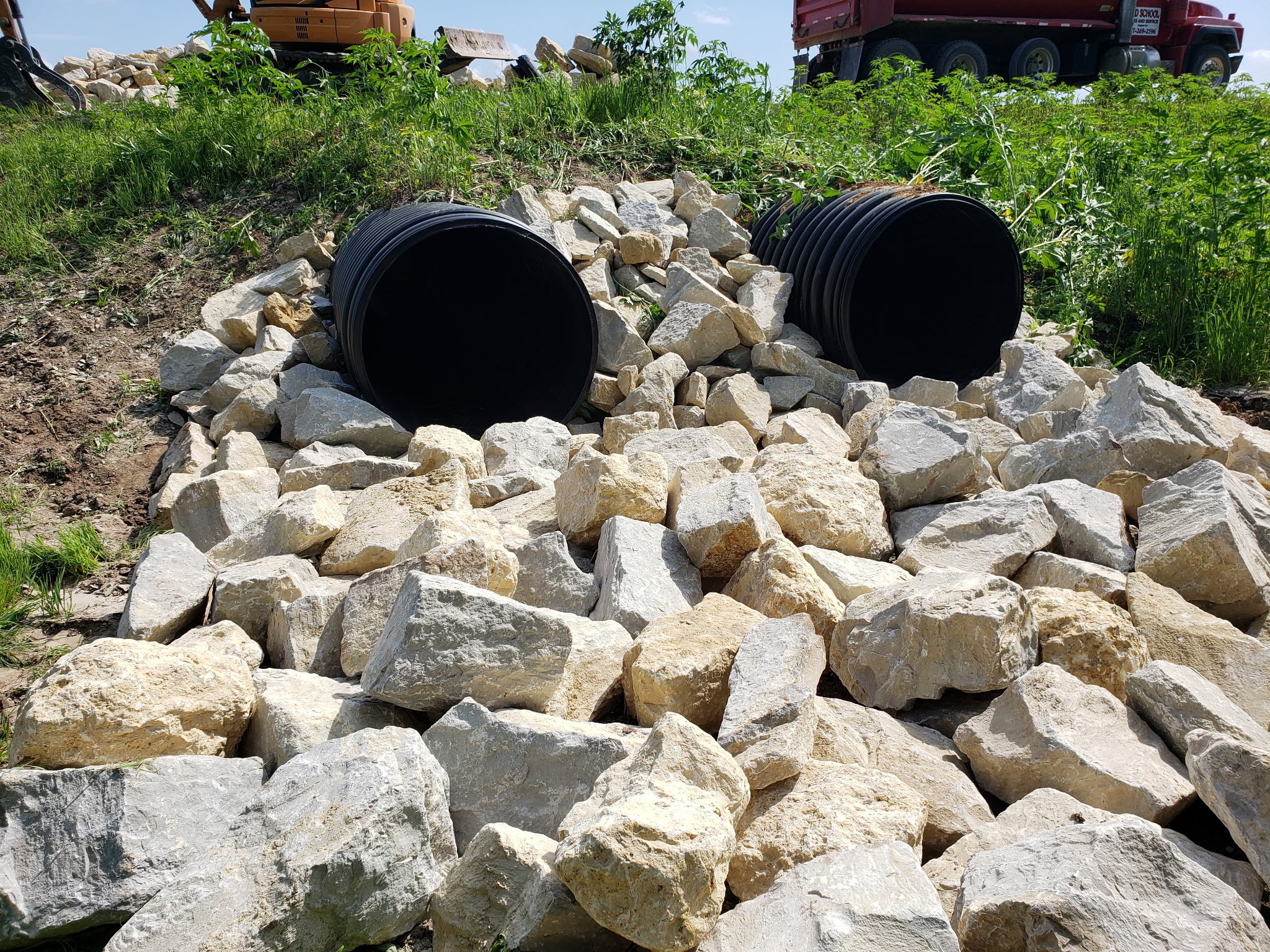 After: Completed culvert outlet with stone rip-rap for erosion control and stability