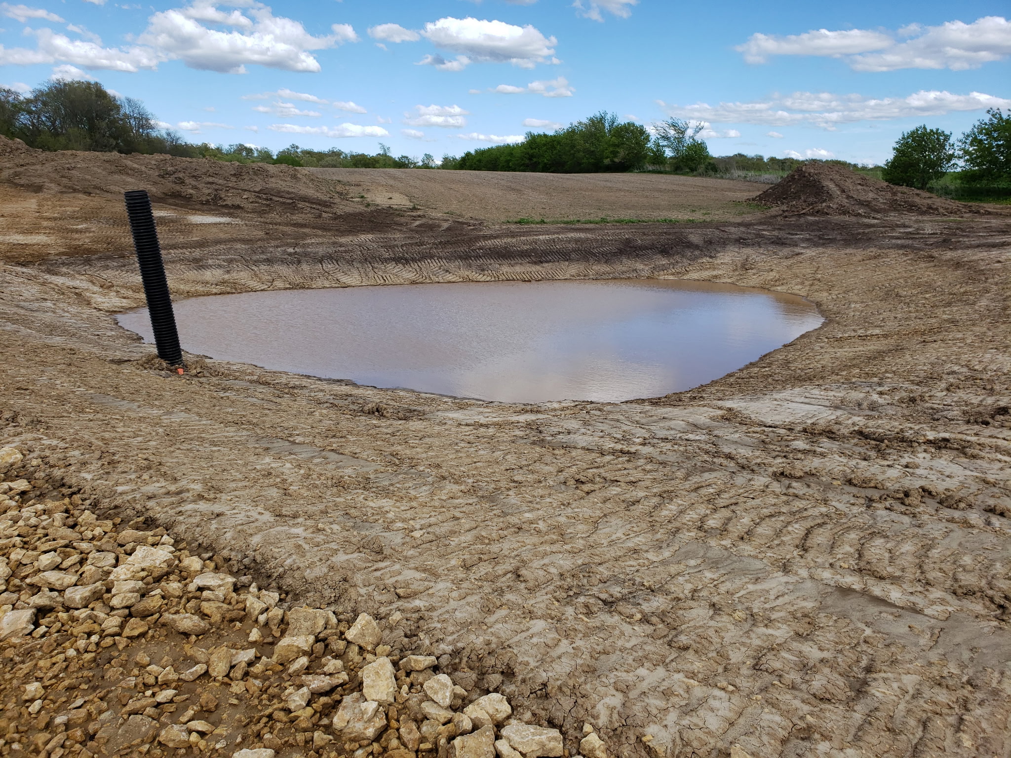 After: Stormwater retention pond filled with water after rainfall