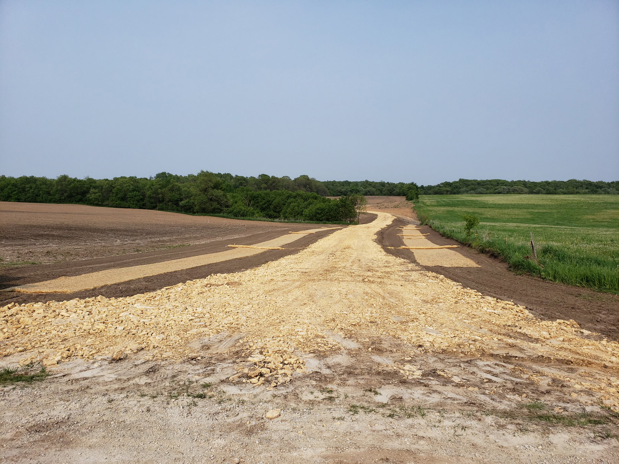 Rural grading project with newly constructed gravel road through farmland