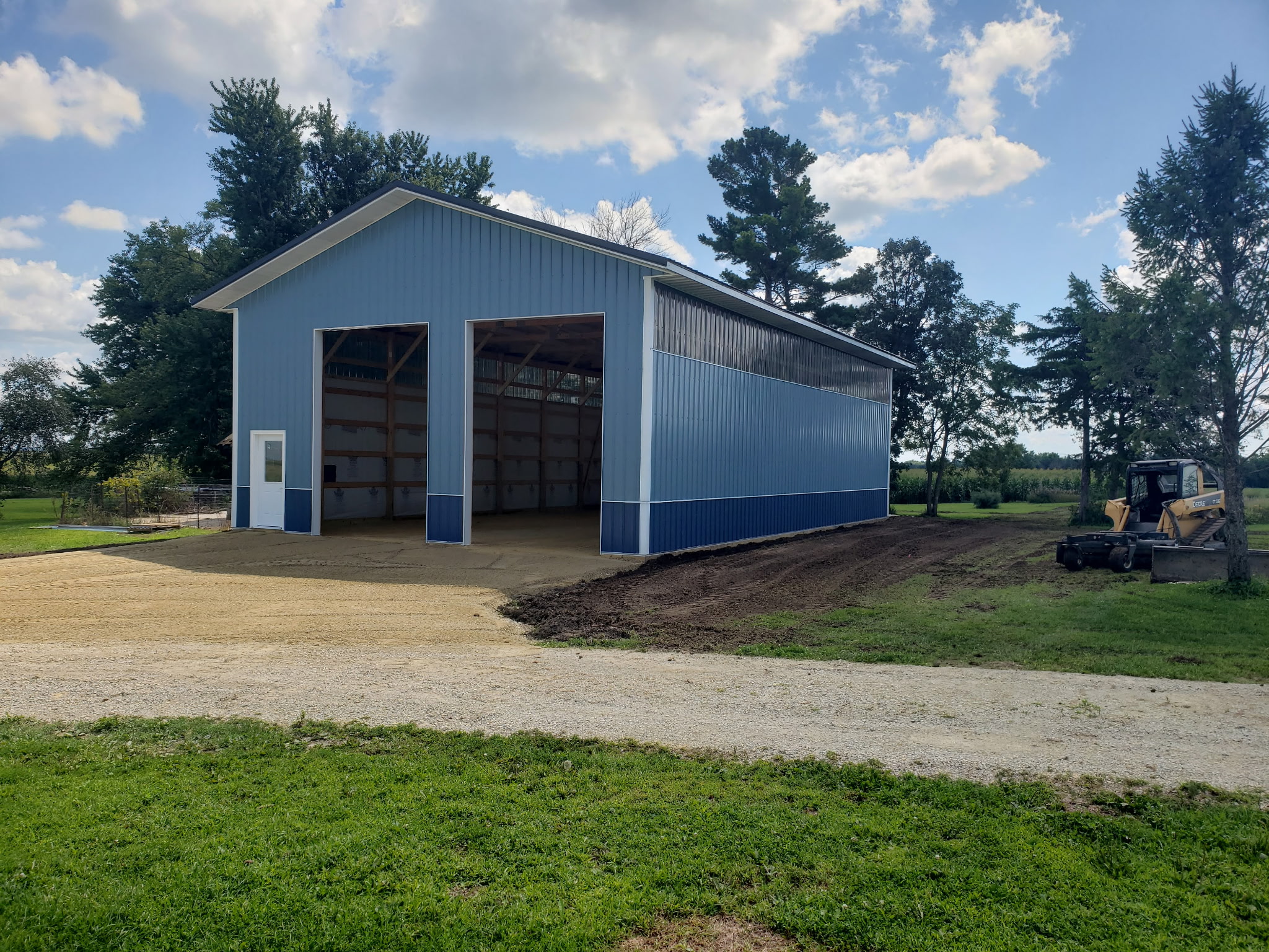 After: Completed pole shed with finished grading and gravel approach